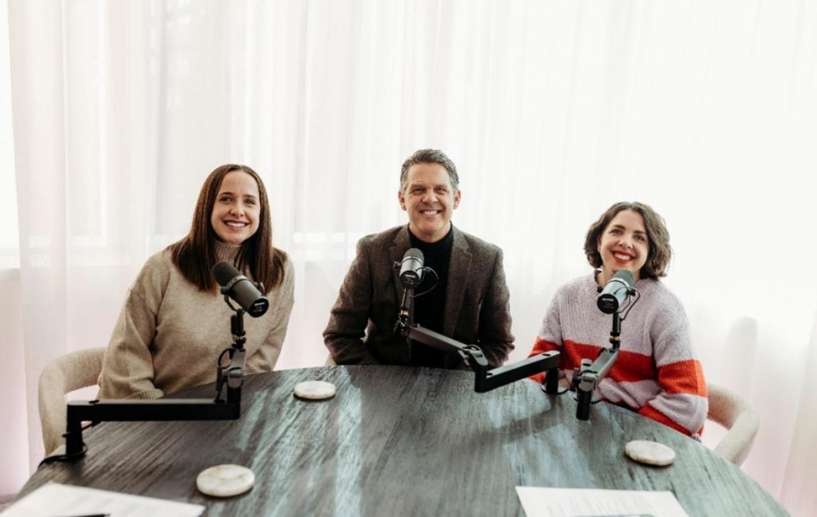 Dementia Advocate Jim Rogers sits at a table with his two daughters on either side of him