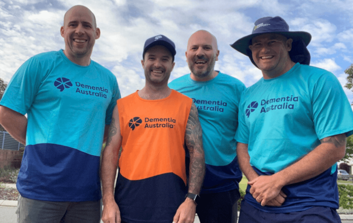 Four people wearing Dementia Australia t-shirts pose for a photo outside.