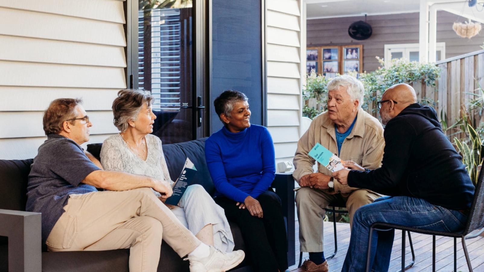 a diverse group of friends having a chat on the porch