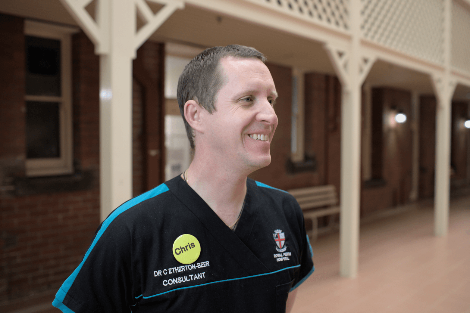 Dr Chris smiling off camera wearing a Royal Perth Hospital shirt