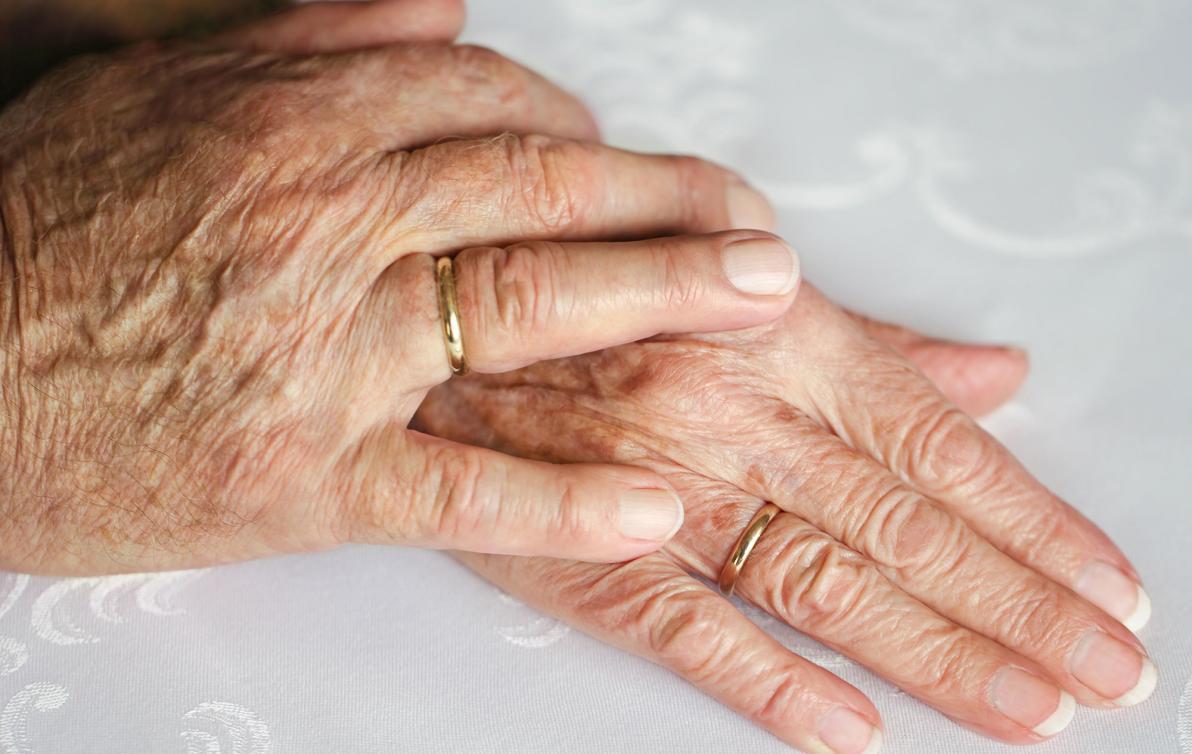 Close up photo of a hand on another hand showing care