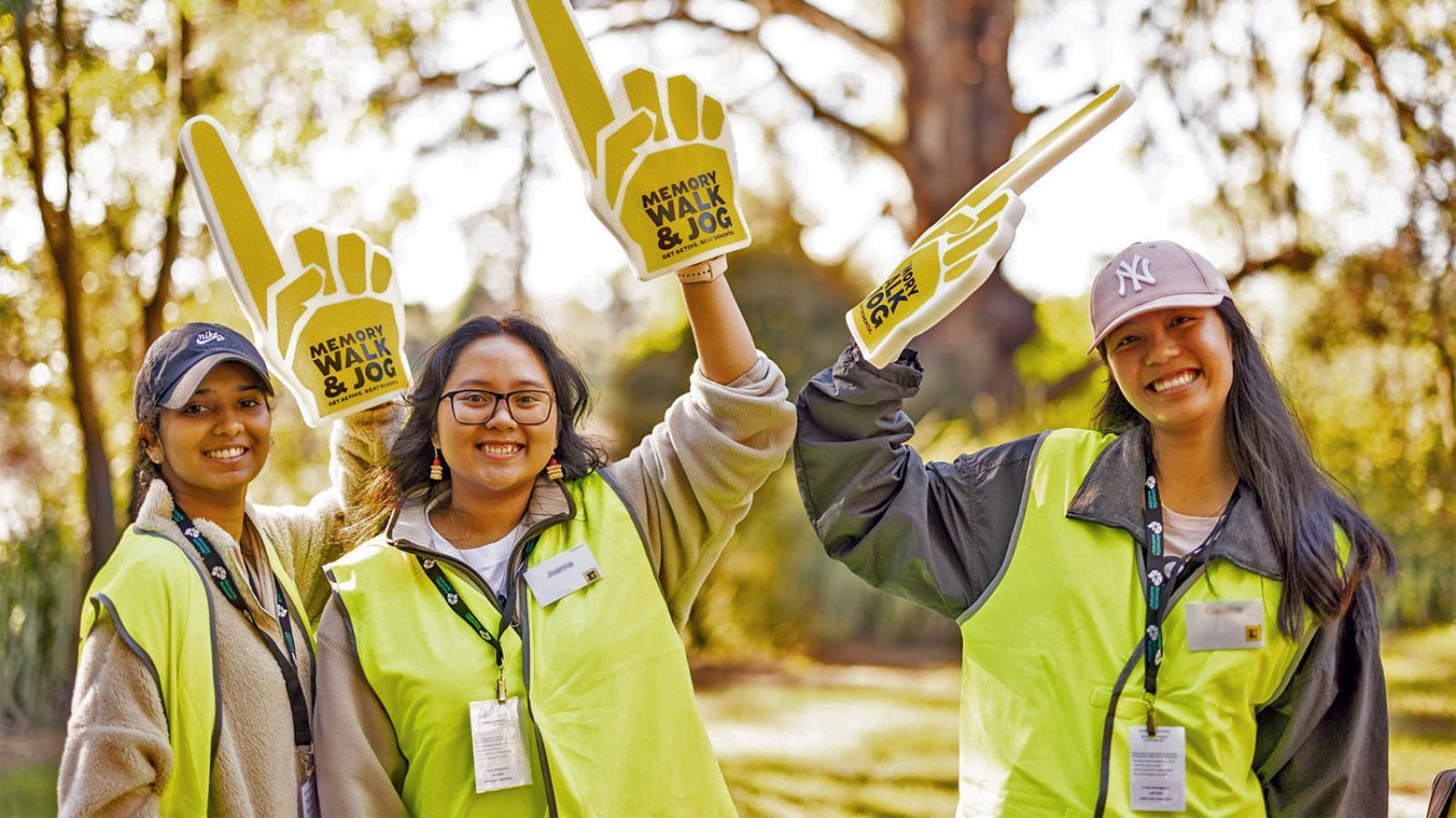 Three volunteers wearing high visibility yellow vests for Memory Walk and Jog